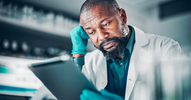 A worried life sciences employee looking at a computer system