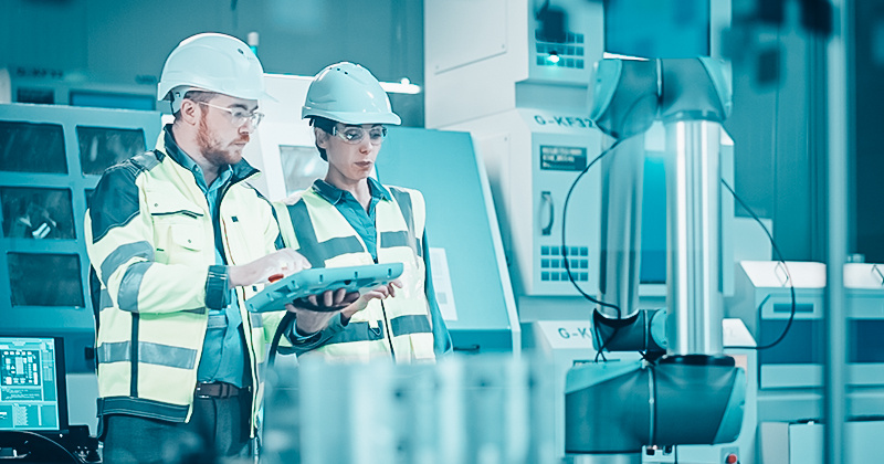 Workers working on a handheld device in a factory