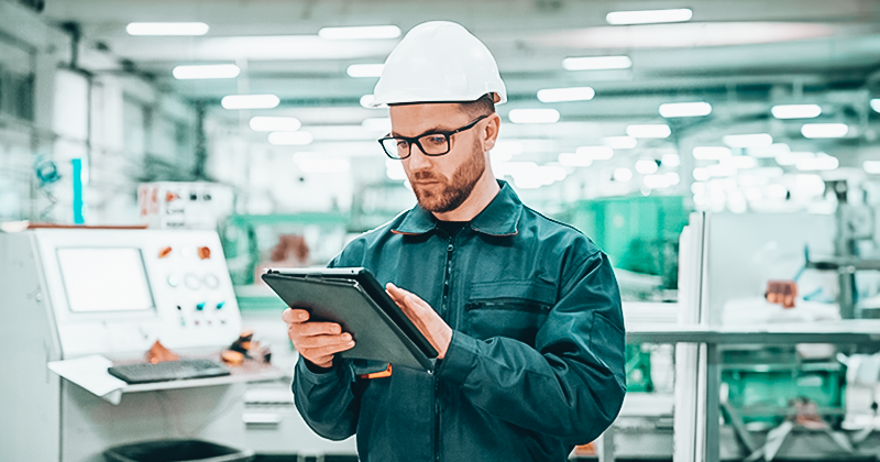 A manufacturer working on a handheld device in a factory