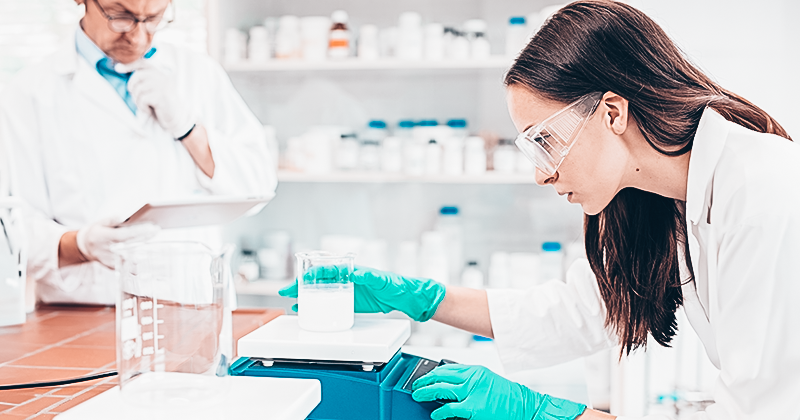 A scientist measuring on a weighing scale in a lab